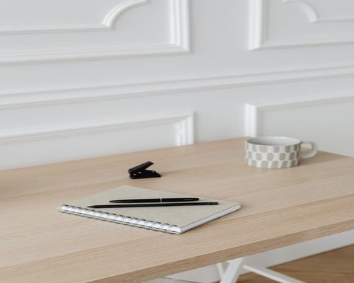 A neat desk with a notebook, pen, and a cup of coffee