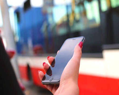 Hands typing on a phone during a bus commute